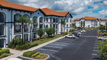 A multi-story residential building with a parking lot in front.