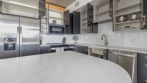 A modern kitchen with a large island, stainless steel appliances, and integrated appliances. - Landing St. Petersburg Near South Branch Potomac River (St. Petersburg)