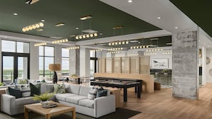 A spacious living area with a sofa, coffee table, and a pool table. There are large windows providing natural light and a view of the outdoors. - Landing St. Petersburg Near South Branch Potomac River (St. Petersburg)