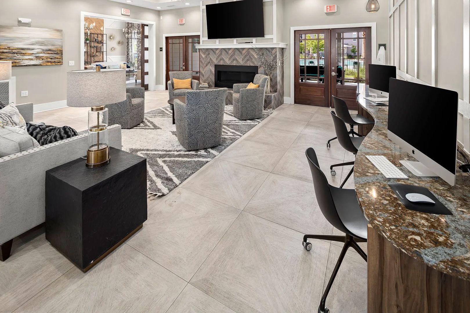A modern hotel lobby with a seating area, a fireplace, and a TV mounted on the wall.