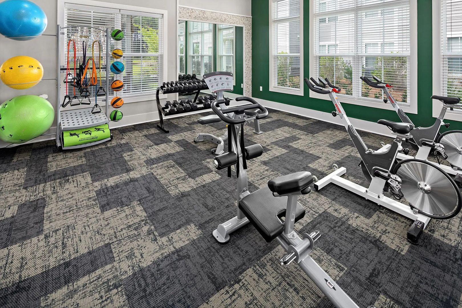 Una palestra con attrezzature per esercizi, tra cui tapis roulant, cyclette e pesi.