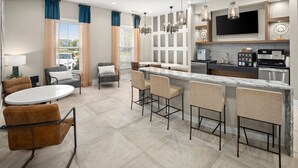Cocina moderna con una isla central, asientos tipo barra y un comedor con mesa redonda y sillas.