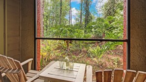 A wooden table with four chairs and a window with a view of a forest. - Landing Jacksonville (Jacksonville)