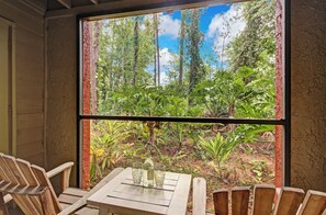 A wooden table with four chairs and a window with a view of a forest. - Landing Jacksonville (Jacksonville)