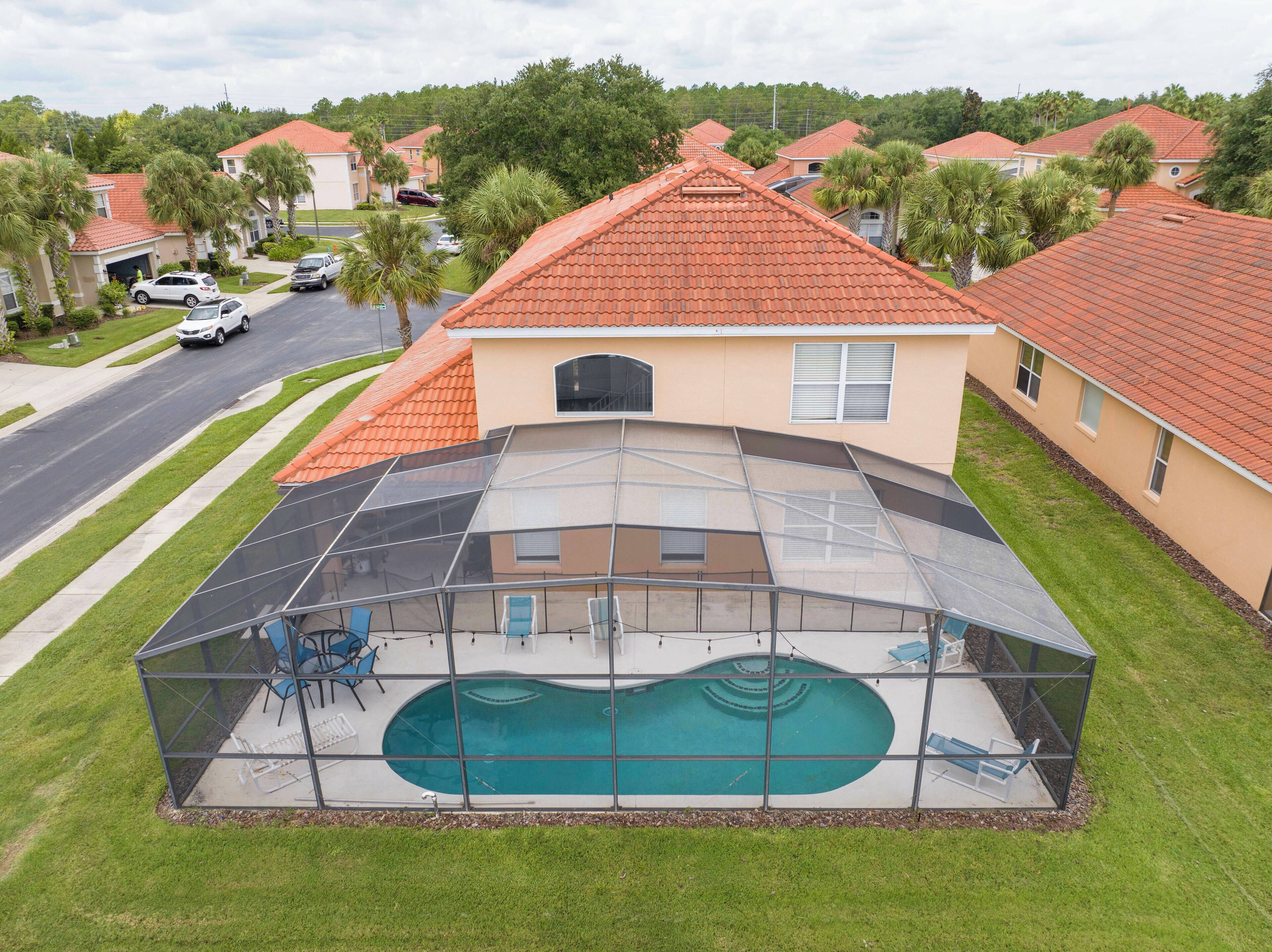 Una casa residenziale con piscina, circondata da una struttura in vetro, situata in un quartiere periferico.