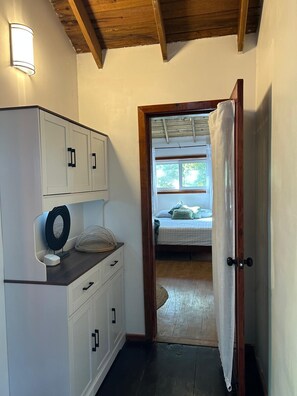 Un dormitorio pequeño con cama, una ventana y una puerta que da a otra habitación.