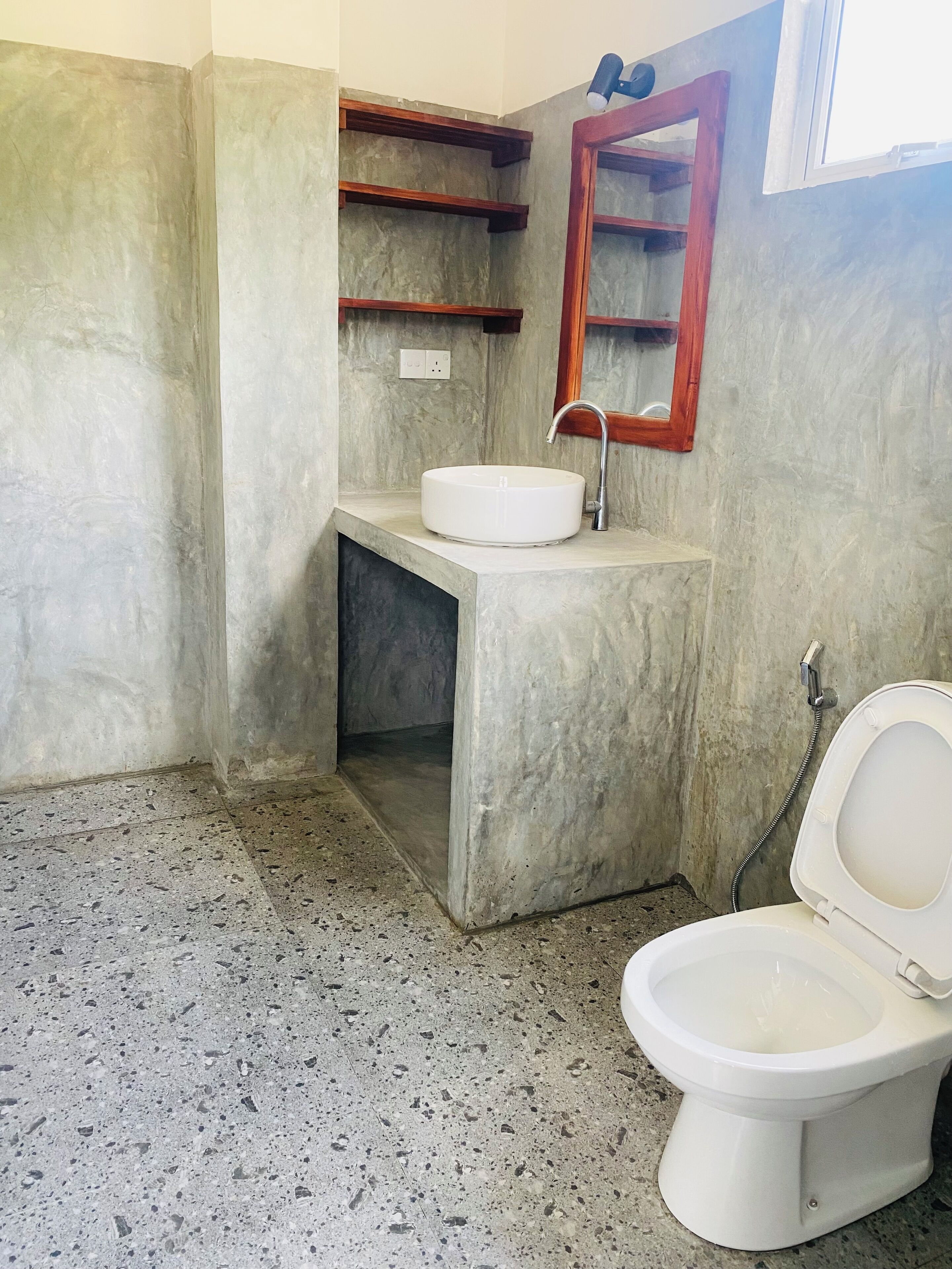 A bathroom with a white sink, a toilet, and a mirror.