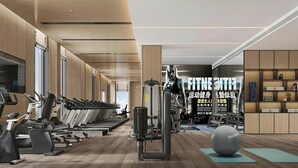 Un gimnasio moderno con equipo de ejercicio, suelo de madera y una gran pelota Reebok.