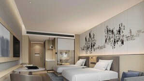 Habitación de hotel moderna con dos camas, un escritorio y una zona de estar.