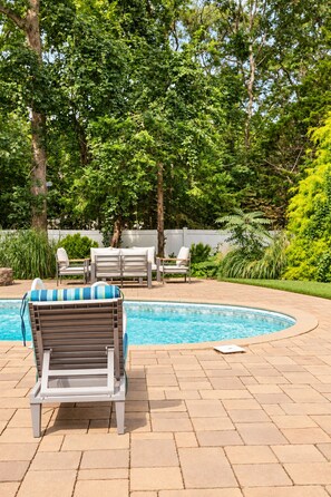 A poolside area with lounge chairs and a swimming pool. - Heated Pool, Gym & Game Room, 5 Min to Beach (Hampton Bays)