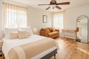 A bedroom with a bed, a sofa, a desk, and a ceiling fan. - Heated Pool, Gym & Game Room, 5 Min to Beach (Hampton Bays)