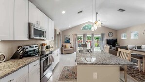 A modern kitchen with granite countertops, stainless steel appliances, and a central island.