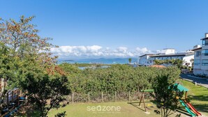 Zona residencial con un parque infantil, jardín vallado y vistas al mar y a las montañas.