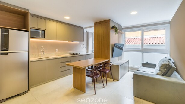 A modern kitchen with a dining area, built-in appliances, and a large window. - Apartment w/ Barbecue 230m From the Beach Ayr0202 (Florianópolis)