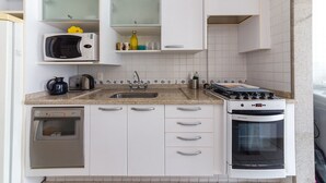 A compact kitchen with a dishwasher, microwave, stove, and oven.