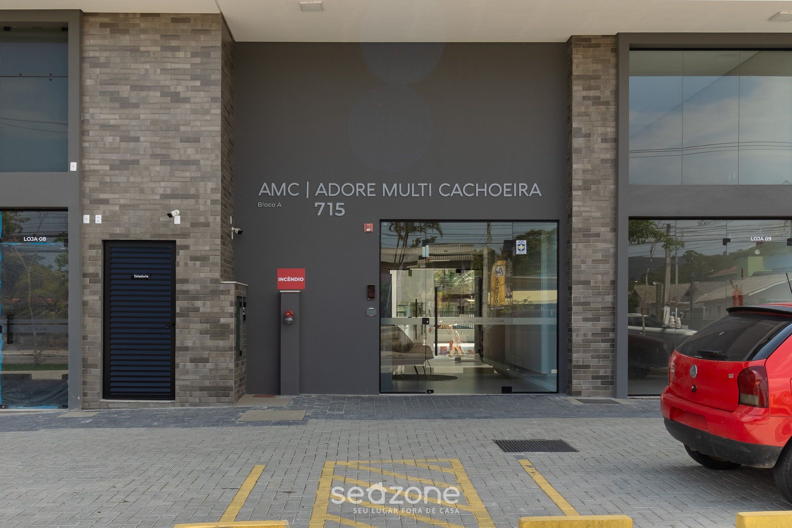 Un edificio moderno con un letrero que dice "AMC | ADORE MULTI CACHOEIRA 715".