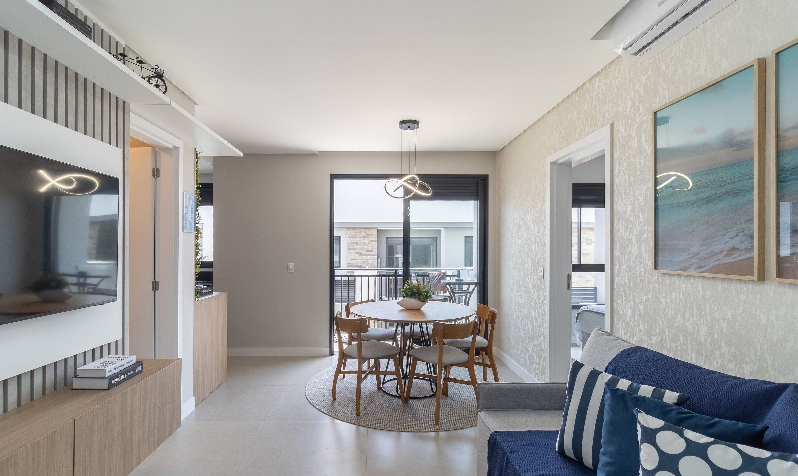 Una sala de estar moderna con una mesa de comedor redonda, un sofá y vistas al balcón.