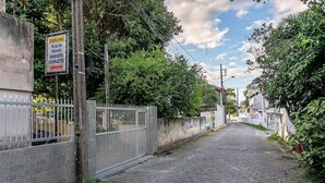 A paved street with a sign indicating directions to places like 'Placas' and 'Banners'. - Studio Near Lagoa da Conceicao BDR (Florianópolis)