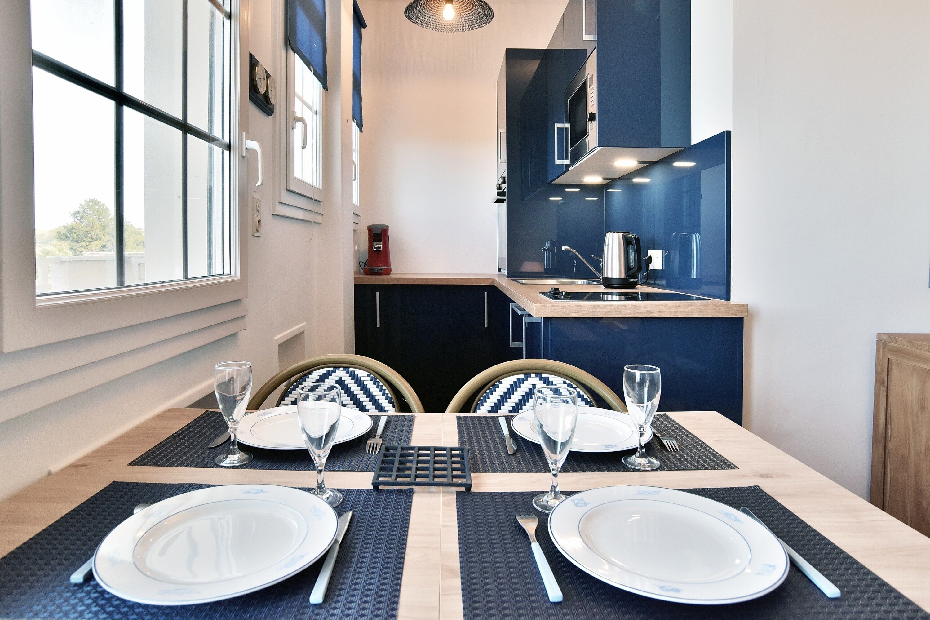 Mesa de comedor para dos con vista a la cocina.