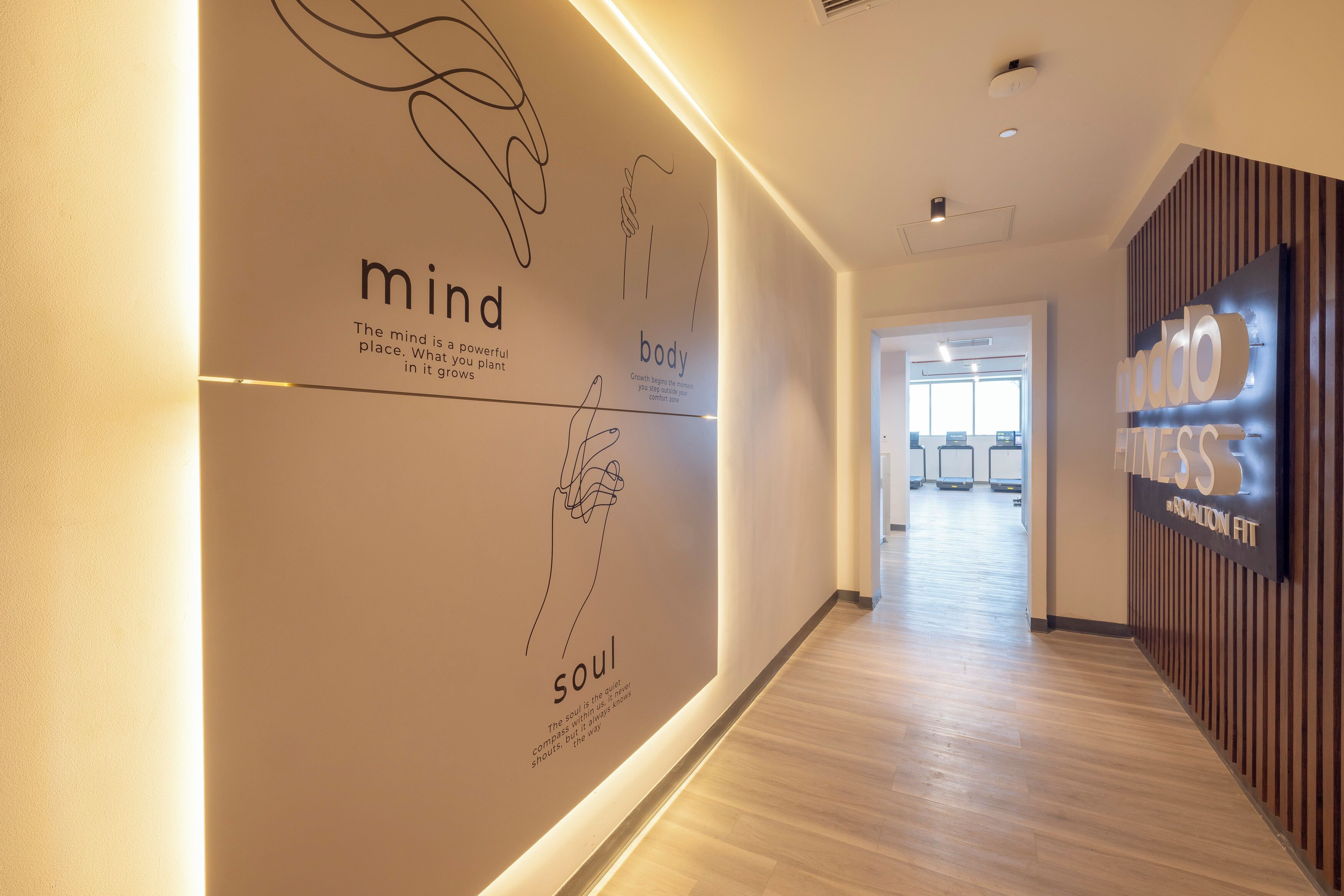 Un pasillo con una pared que presenta texto sobre la mente, el cuerpo y el espíritu.