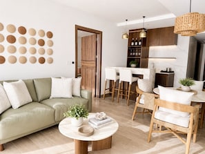 Un salon moderne avec un canapé, une table basse et un coin repas.