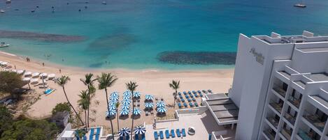 A resort with a pool, beach, and ocean view.