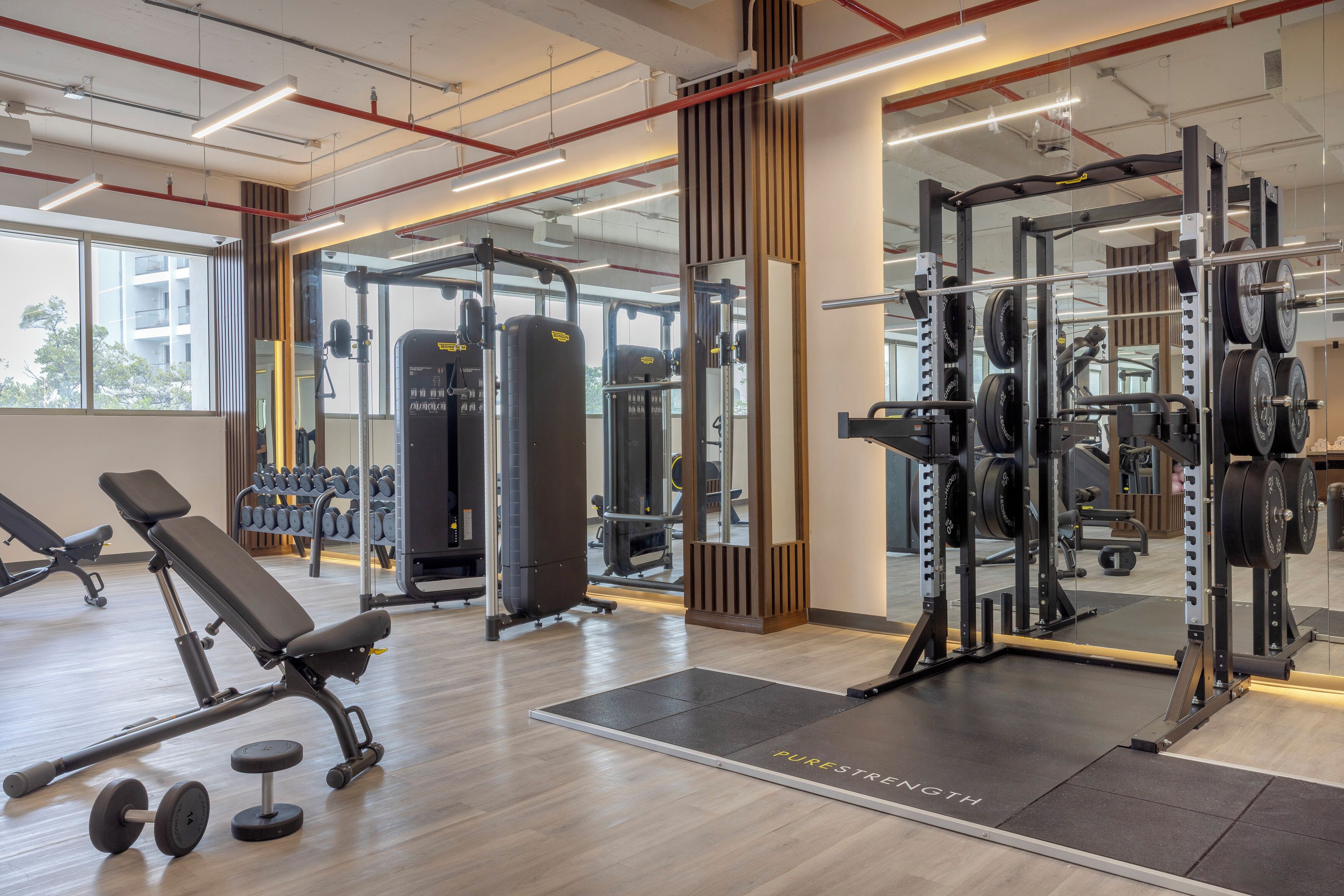 Une salle de sport équipée de matériel de musculation, d’un banc et d’haltères.
