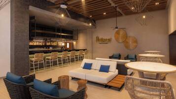 A modern lounge area with a bar, seating, and a visible restaurant sign.