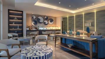 A modern lounge area with a bar, seating, and decorative wall art.