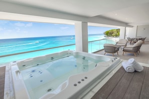 A balcony with a hot tub, outdoor seating, and a view of the ocean. - Royalton Vessence Barbados Adult-Oriented, an Autograph Collection All-Inclusive Resort – Now Open (Holetown)