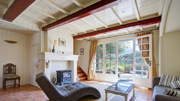 A cozy living room with a fireplace, comfortable seating, and a view of the outdoors. - Catlove - Piscine Privée (Eus)