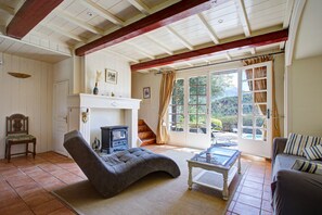 Un salon chaleureux avec une cheminée, des sièges confortables et une vue sur l’extérieur.