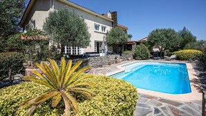 A house with a swimming pool, stone patio, and lush greenery. - Catlove - Piscine Privée (Eus)