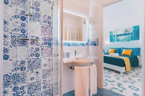 A bathroom with a shower, sink, and mirror.
