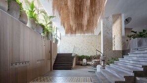 A modern interior with a staircase, wooden paneling, and hanging plants. - BOSA HOTELS & RESIDENCES (Bucerias)