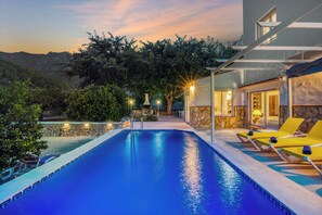 A swimming pool with lounge chairs and a stone wall. - Relax Natural: Private Pool, BBQ & A/C — 15 minutes from Cullera (Llaurí)