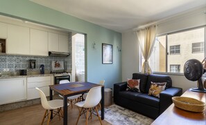 A compact living space with a kitchenette, dining area, and seating area. - Condominium in Floripa 300m From the Beach - CAS (Florianópolis)
