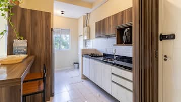 Una cocina moderna con armarios de madera, encimera negra y estufa integrada.
