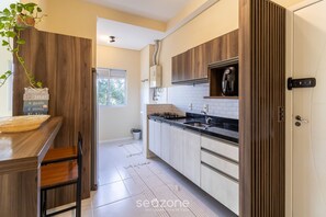 A modern kitchen with wooden cabinets, a black countertop, and a built-in stove.