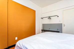 A bedroom with a bed, a wardrobe, and a mirror. - Practical Apt in Downtown 350m SC Museum Cat406 (Florianópolis)