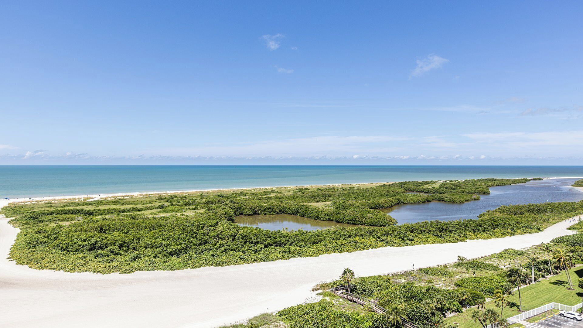 Eine Küstenlandschaft mit Strand, Mangroven und freiem Blick auf den Ozean.