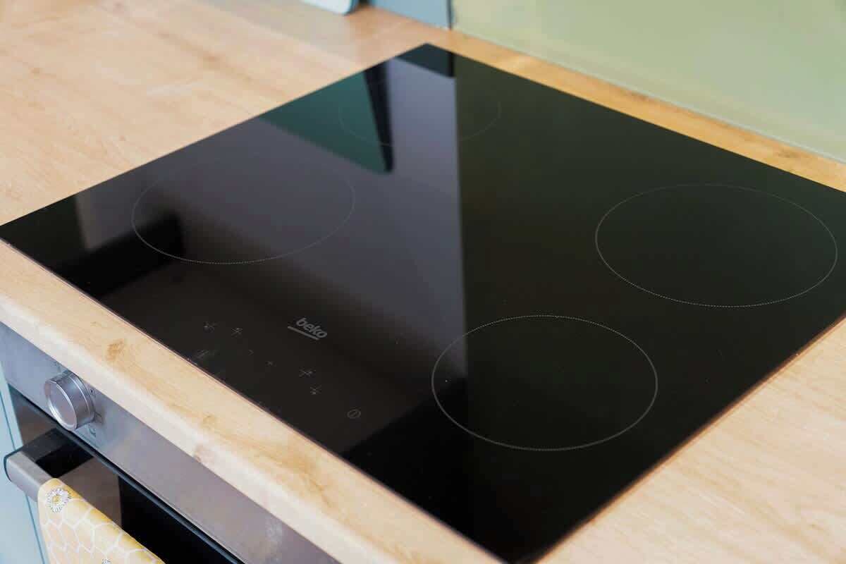 Eine schwarze Induktionskochplatte mit einer Holzarbeitsplatte.