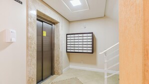 An elevator with a sign above it, a mail slot with labels, and a handrail on a staircase. - Charming apt Just 350m From the Beach! - Vgn0102 (Florianópolis)