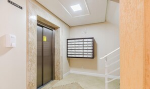 An elevator with a sign above it, a mail slot with labels, and a handrail on a staircase. - Charming apt Just 350m From the Beach! - Vgn0102 (Florianópolis)