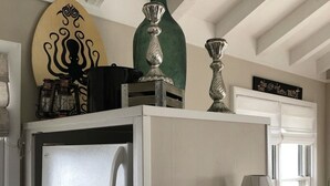 Eine Küche mit einem weißen Kühlschrank, einem grünen Blumentopf und einem dekorativen Schild mit einem Oktopus.