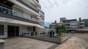 A modern building with balconies and a large blue water feature in the courtyard. - Apartment With Barbecue in Itacorubi Aft0210 (Florianópolis)