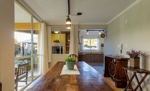 A spacious kitchen with a wooden table, a potted plant, and a large window. - House in Condo w/ Pool, 300m From the Beach Ali024 (Florianópolis)