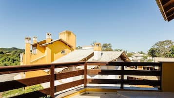 Un balcón con baranda de madera con vistas a una zona residencial.