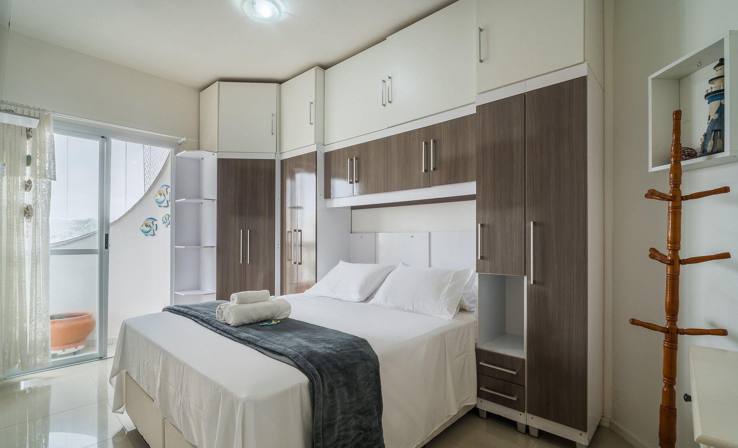 A bedroom with a bed, wardrobe, and a small shelf unit.