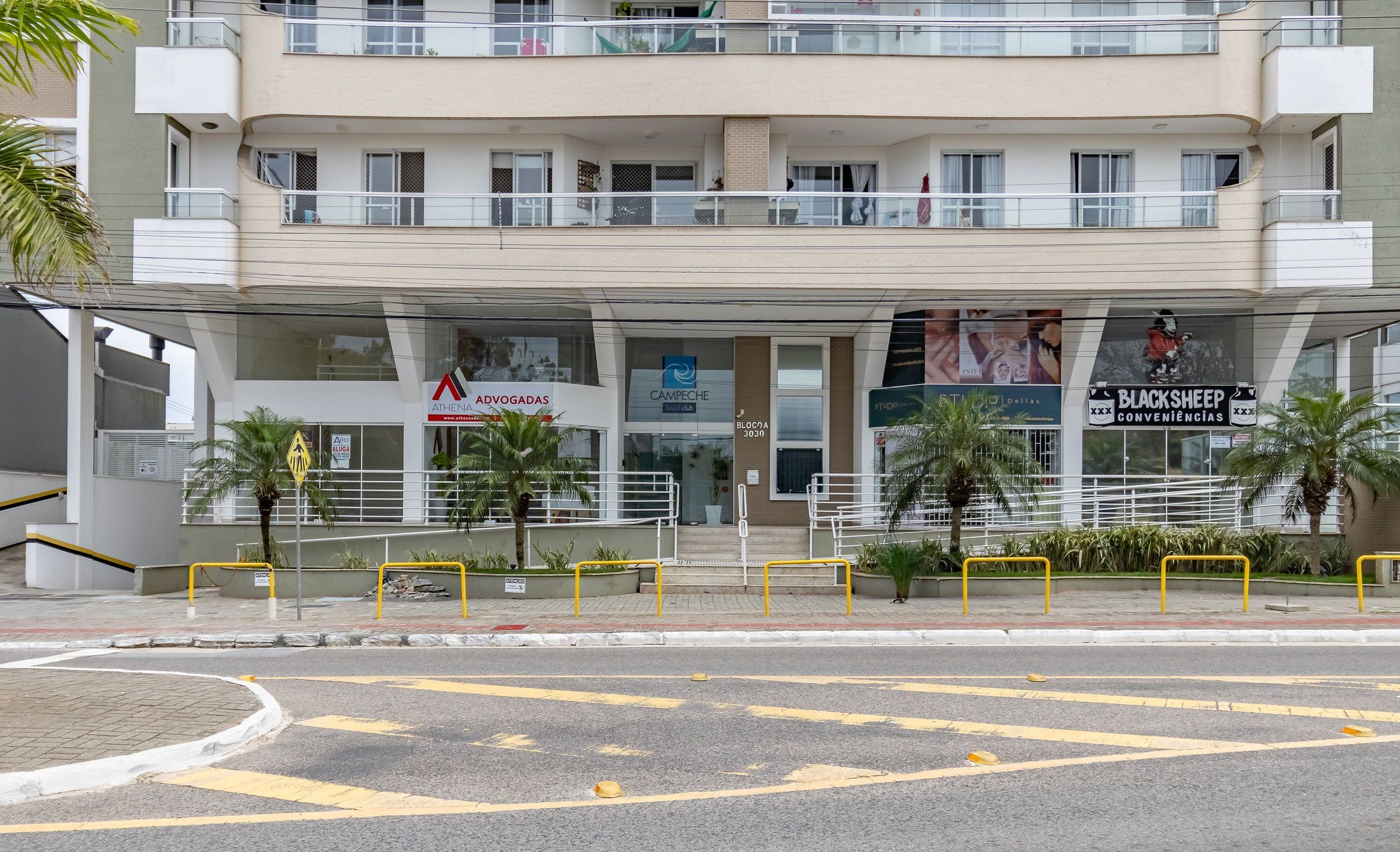 A multi-story building with a commercial ground floor featuring various businesses, including a bank and a convenience store.